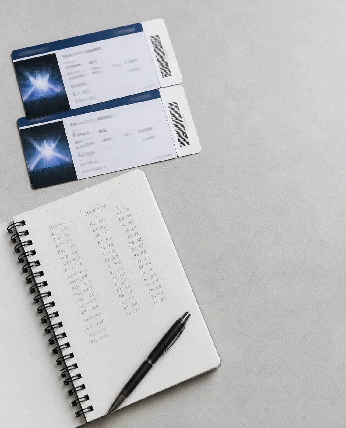 Concert tickets next to a notebook with resale calculations